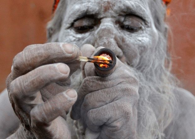 A Hindu ascetic smokes marijuana outside the Bhavnath temple during the Mahashivratri festival in Gujarat